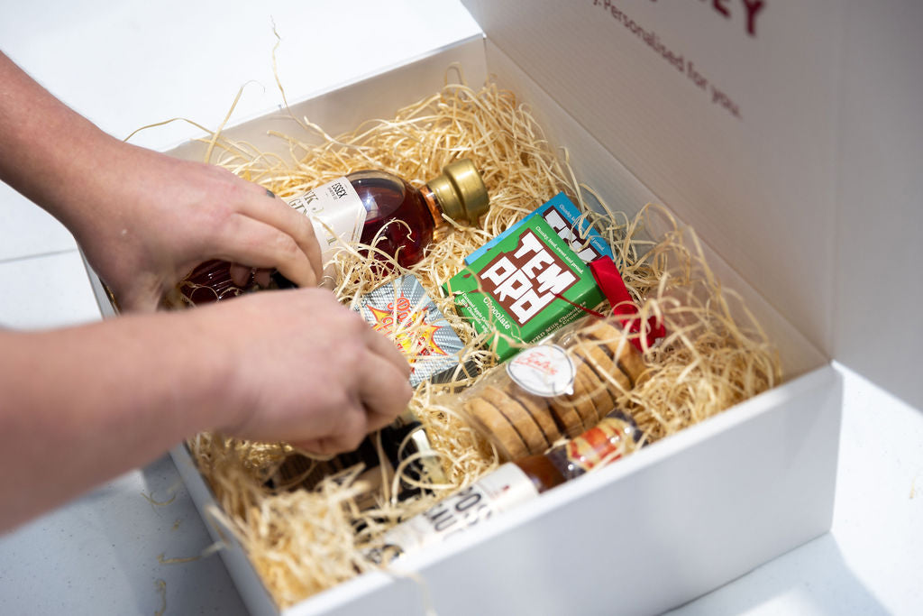 A personalised Hamper from Stort Valley Gifting being filled with chocolate, gin, biscuits and other treats