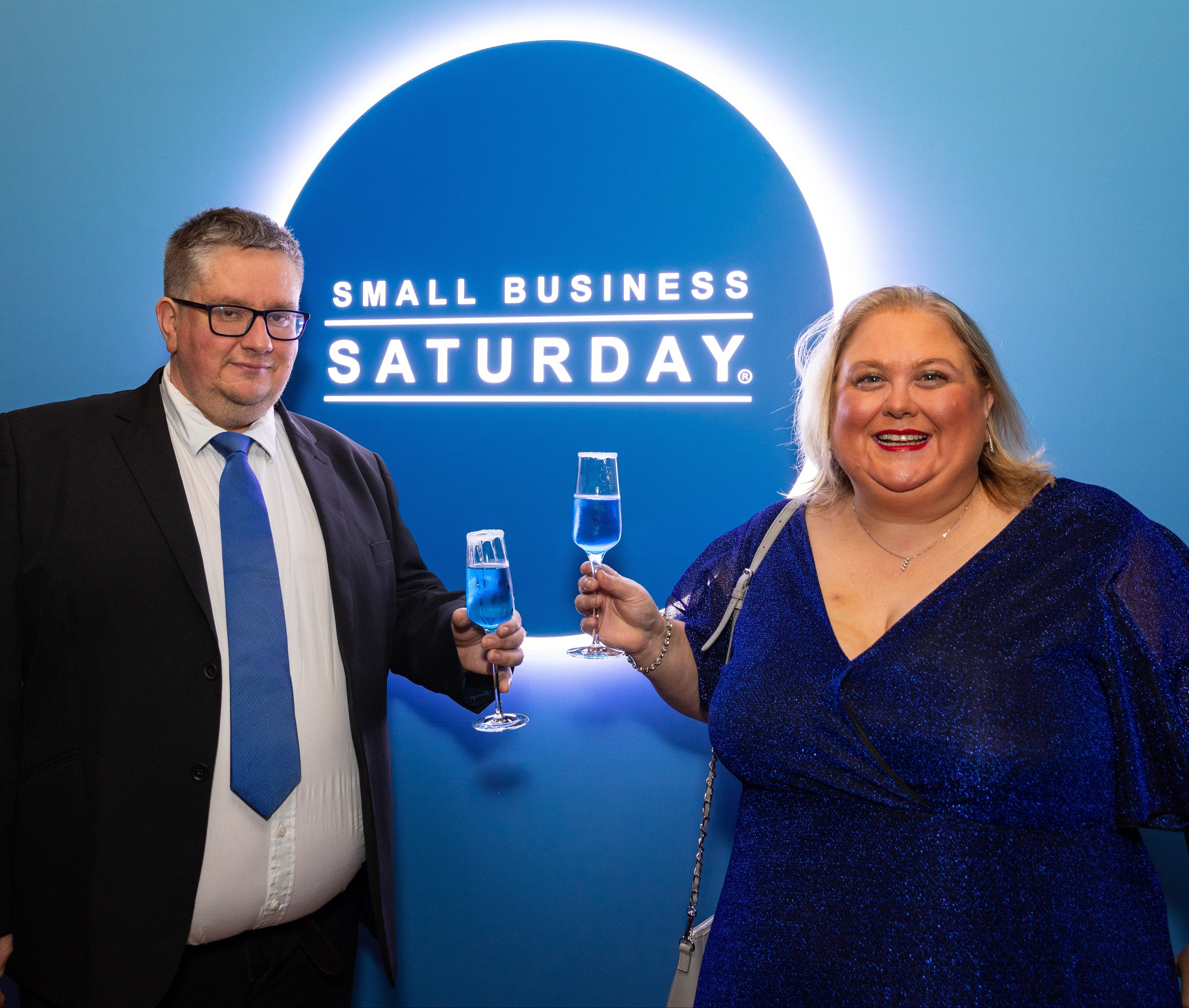 Emma and Rob Robson celebrating Small Business Saturday with blue drinks against a blue background