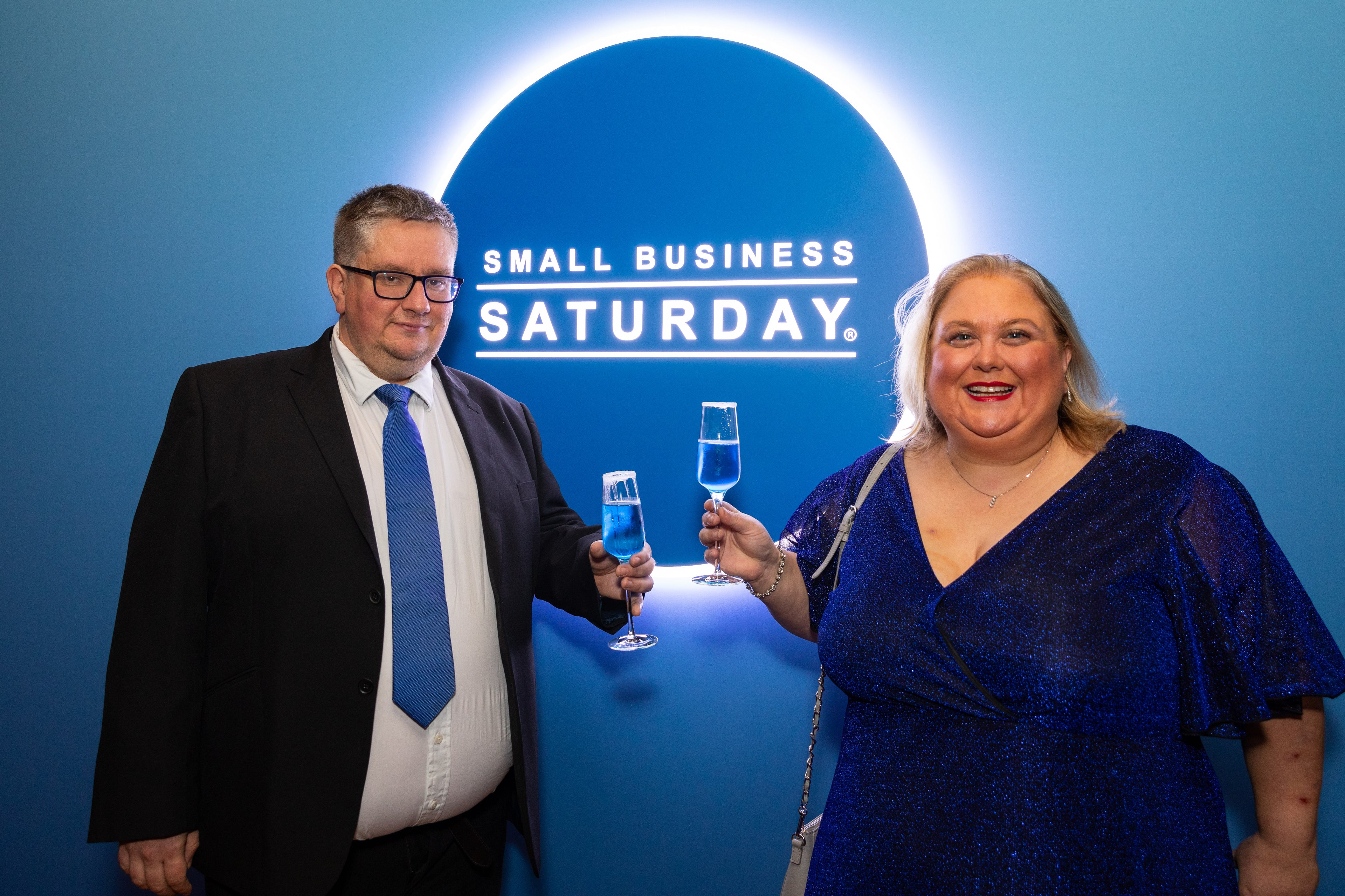 Emma and Rob Robson celebrating Small Business Saturday with blue drinks against a blue background