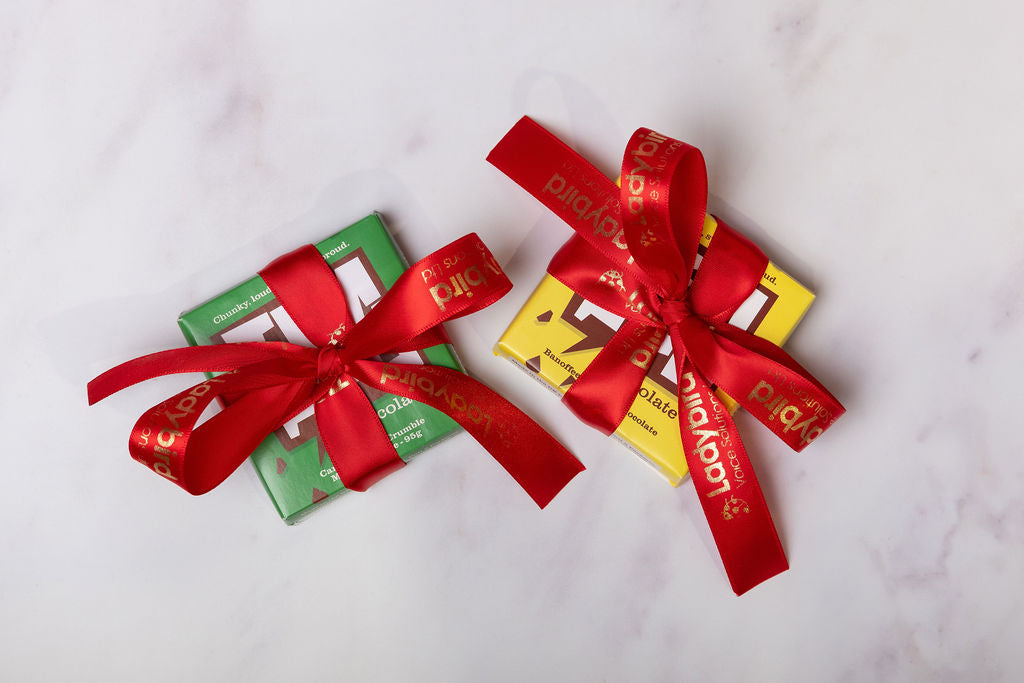 Two Temprd chocolate bars with Personalised Stort Valley red ribbons on a white background