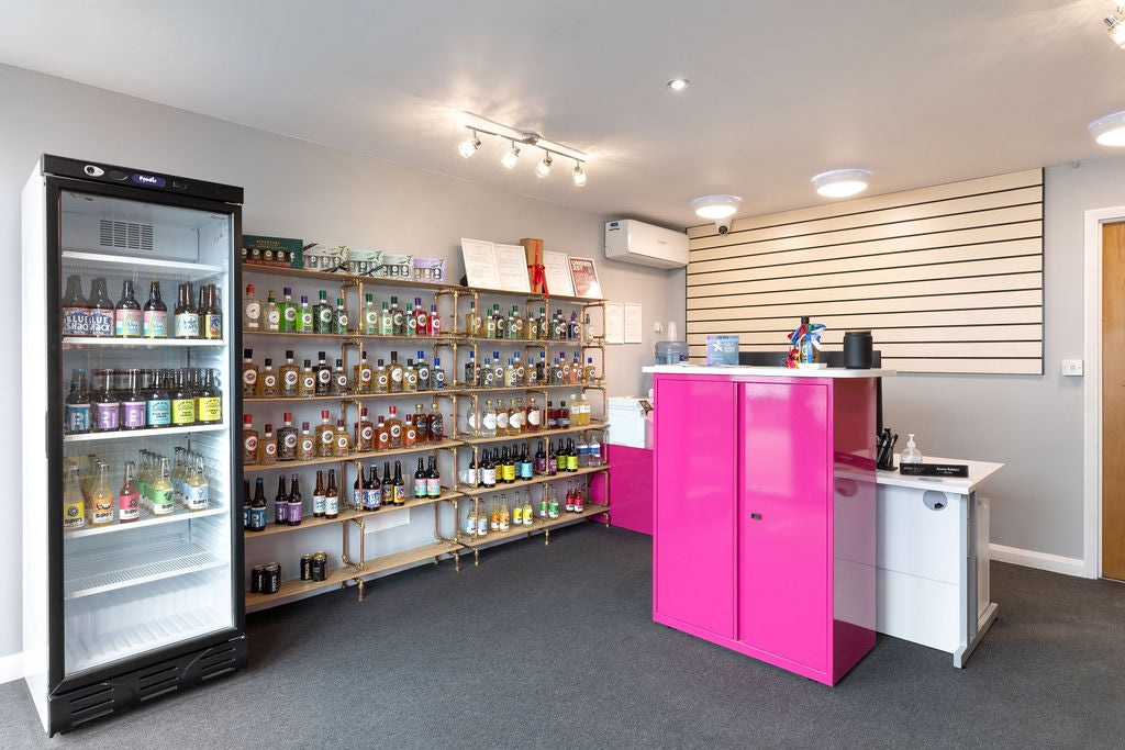 Stort Valley Gifting Hamper Hub Alcohol bottles on shelves and fridge next to a pink cabinet.