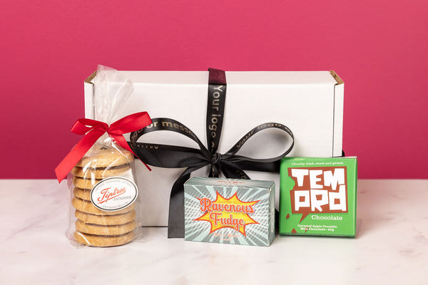 Personalised Stort Valley Gift box with cookies, fudge, and chocolate against a pink background