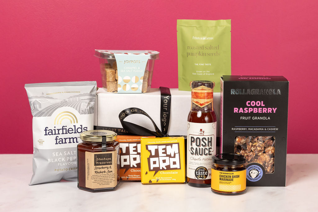 Stort Valley Gifting personalised hamper containing a collection of food products including jars, packets, and a box on a pink background