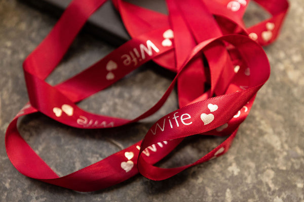 Red ribbon with 'Wife' and heart patterns on a textured surface from Stort Valley Gifting