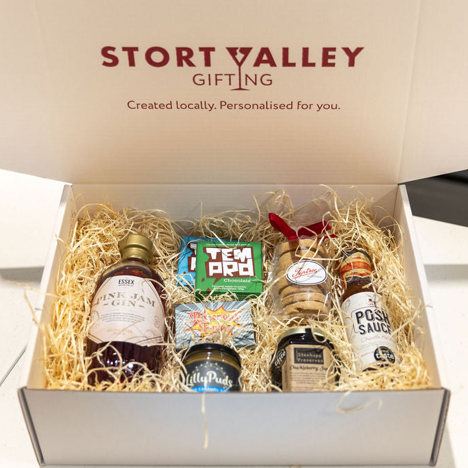 Gift box from Stort Valley Gifting with various items including gin bottles, biscuits, chocolate and sauce presented in a branded gift box
