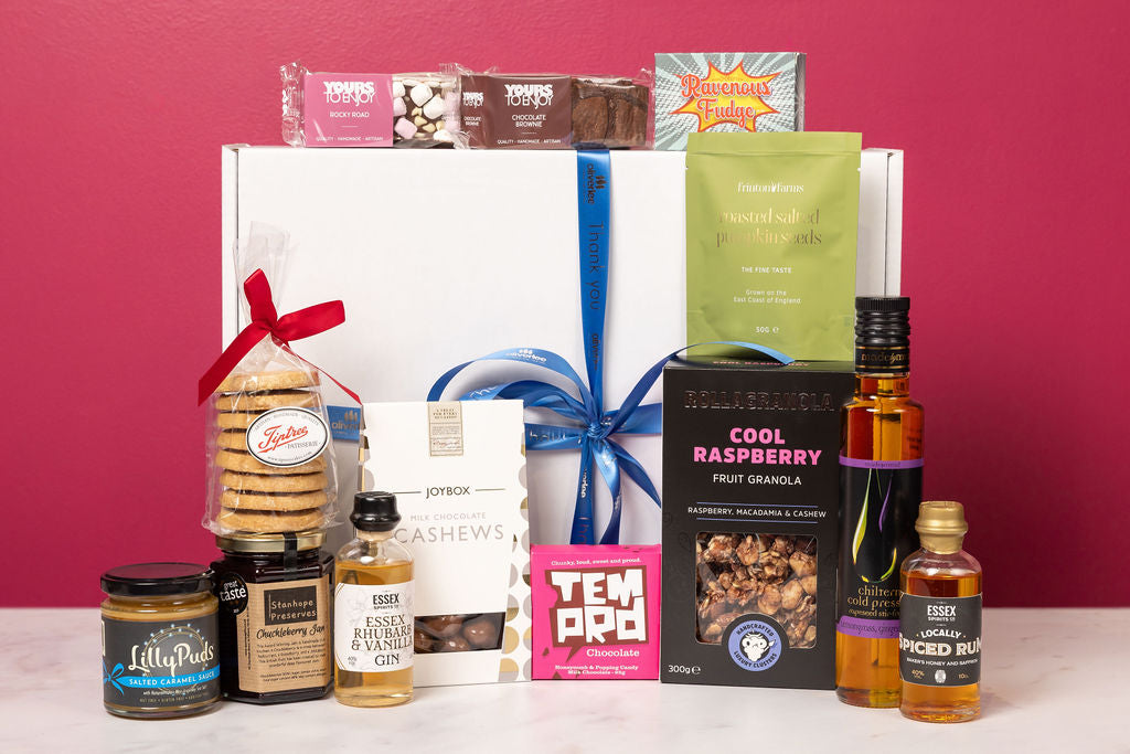 The Stort Valley Gifting celebration gift box including: Assorted food and drink products on a white surface with a red background