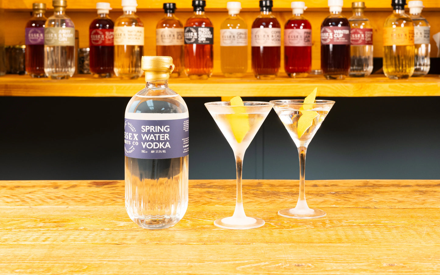 Bottle of 'Spring Water' vodka with two cocktails on a wooden bar counter available at Stort Valley Gifting