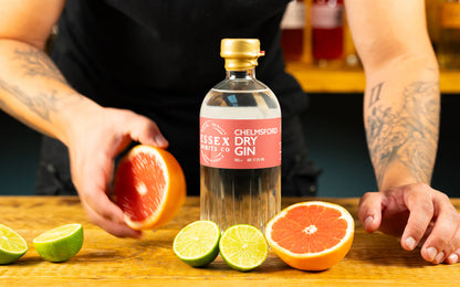 Bottle of Chelmsford Gin with citrus fruits on a wooden surface available at Stort Valley Gifting