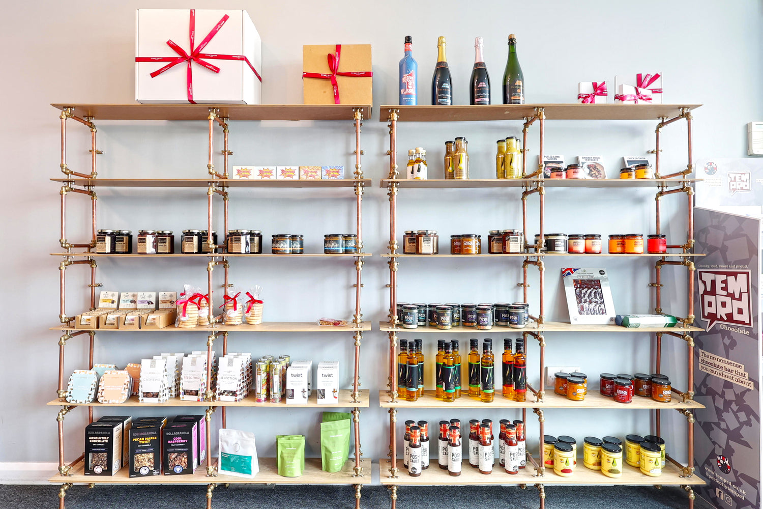 Shelves at the Stort Valley Gifting Hamper hub with various products against a light blue wall
