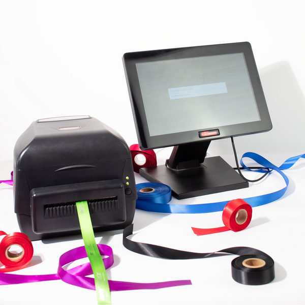 Label printer used at Stort Valley Gifting with a monitor and colourful ribbon rolls on a white background