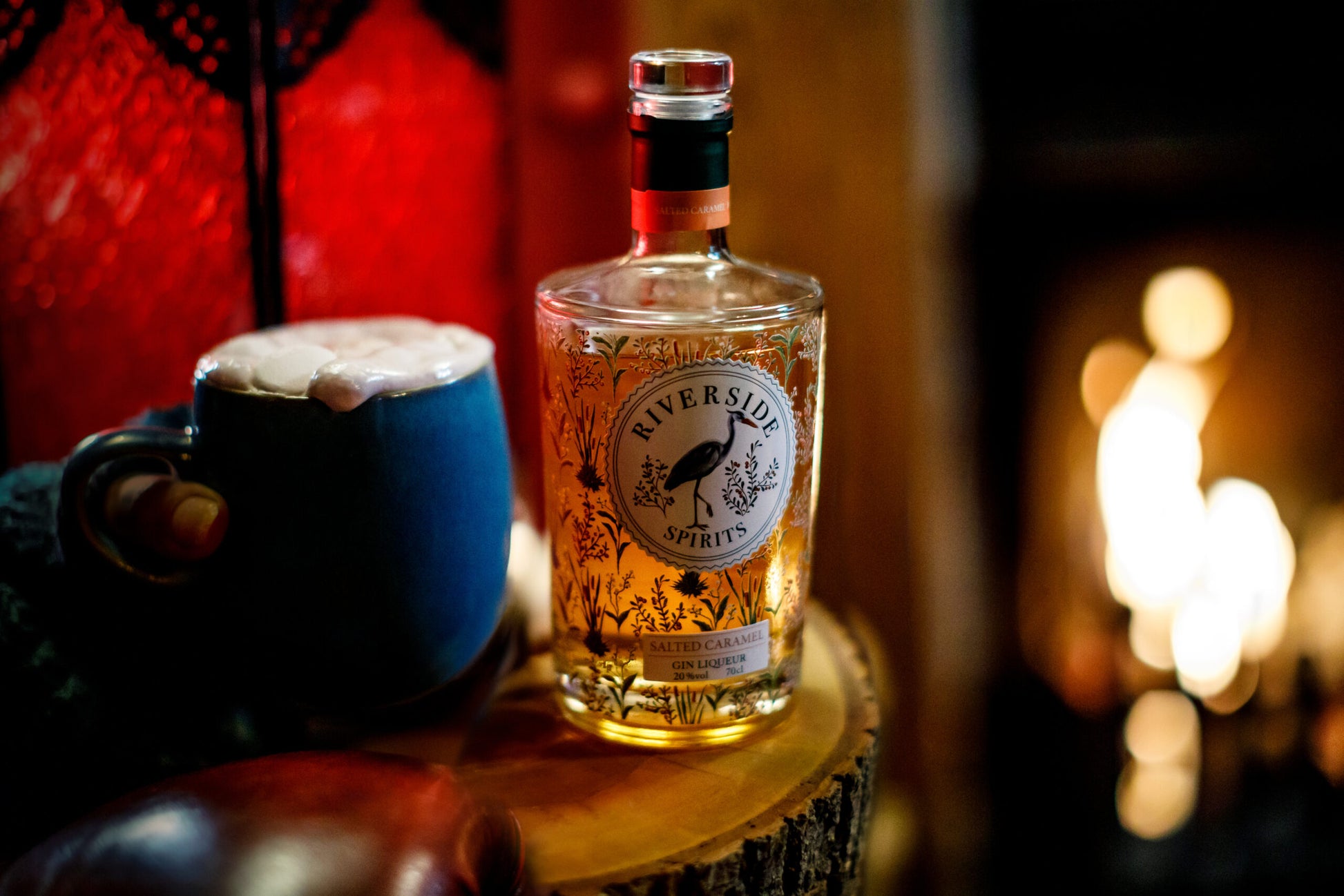 Bottle of Riversider Spirits, Salted Caramel Gin Liqueur on a wooden surface with a blurred background