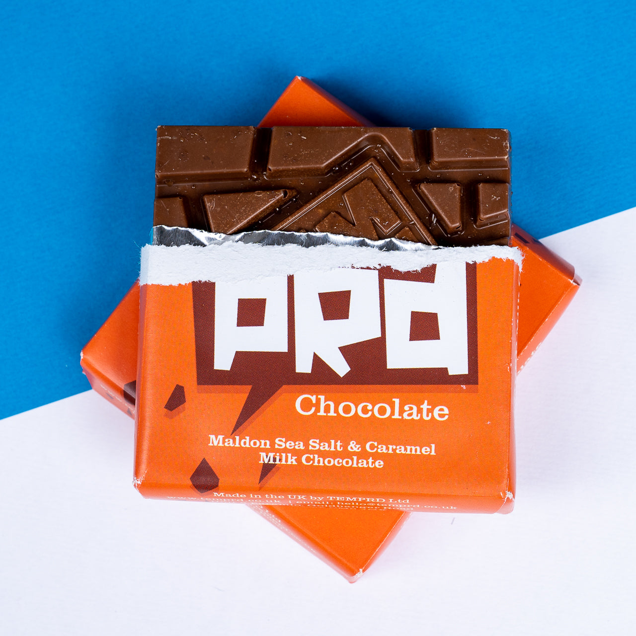 Open Temprd Maldon Sea Salt and Caramel Chocolate bar with visible chocolate pieces on a blue and white background available from Stort Valley Gifting