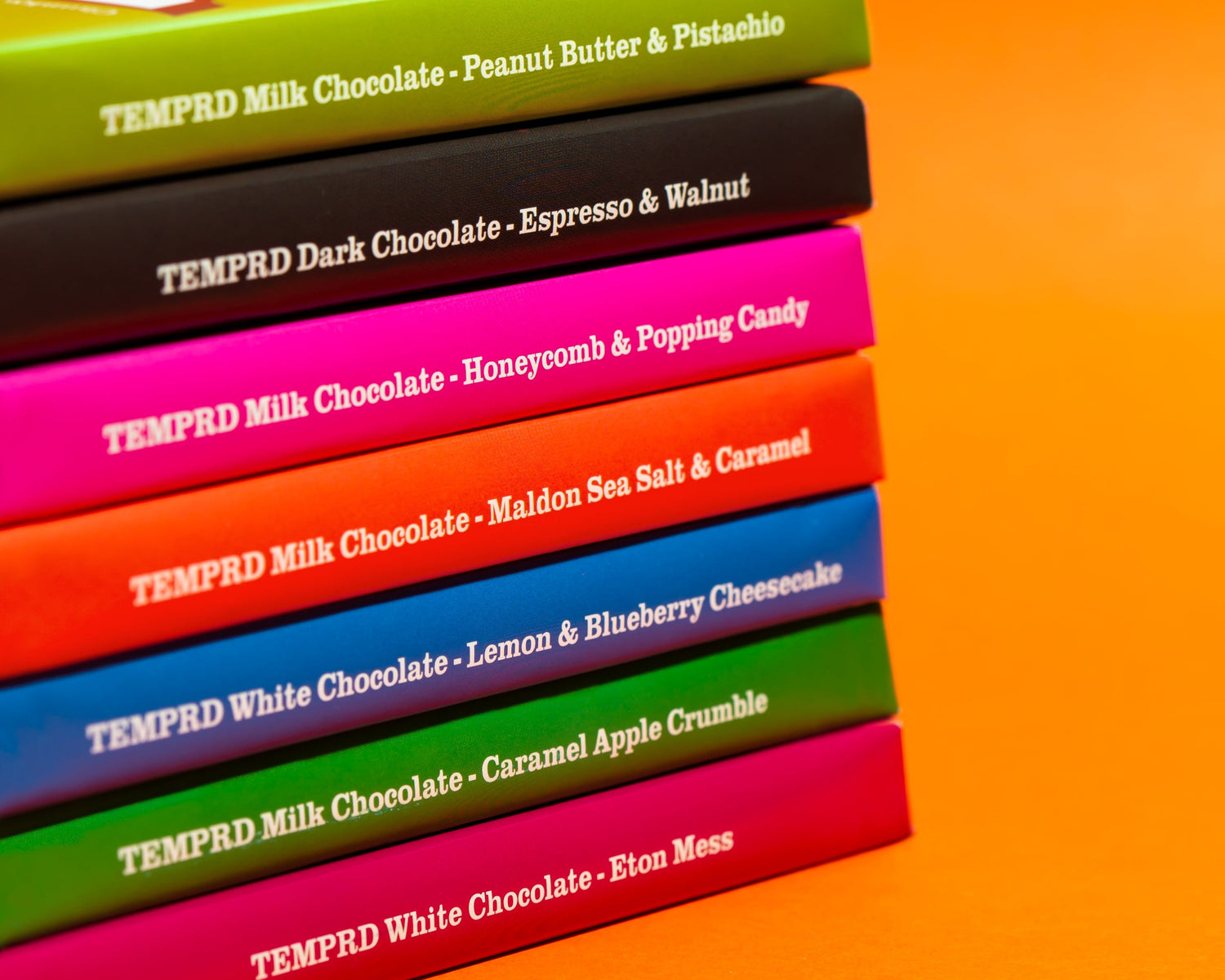 Stack of colorful chocolate boxes with text on an orange background