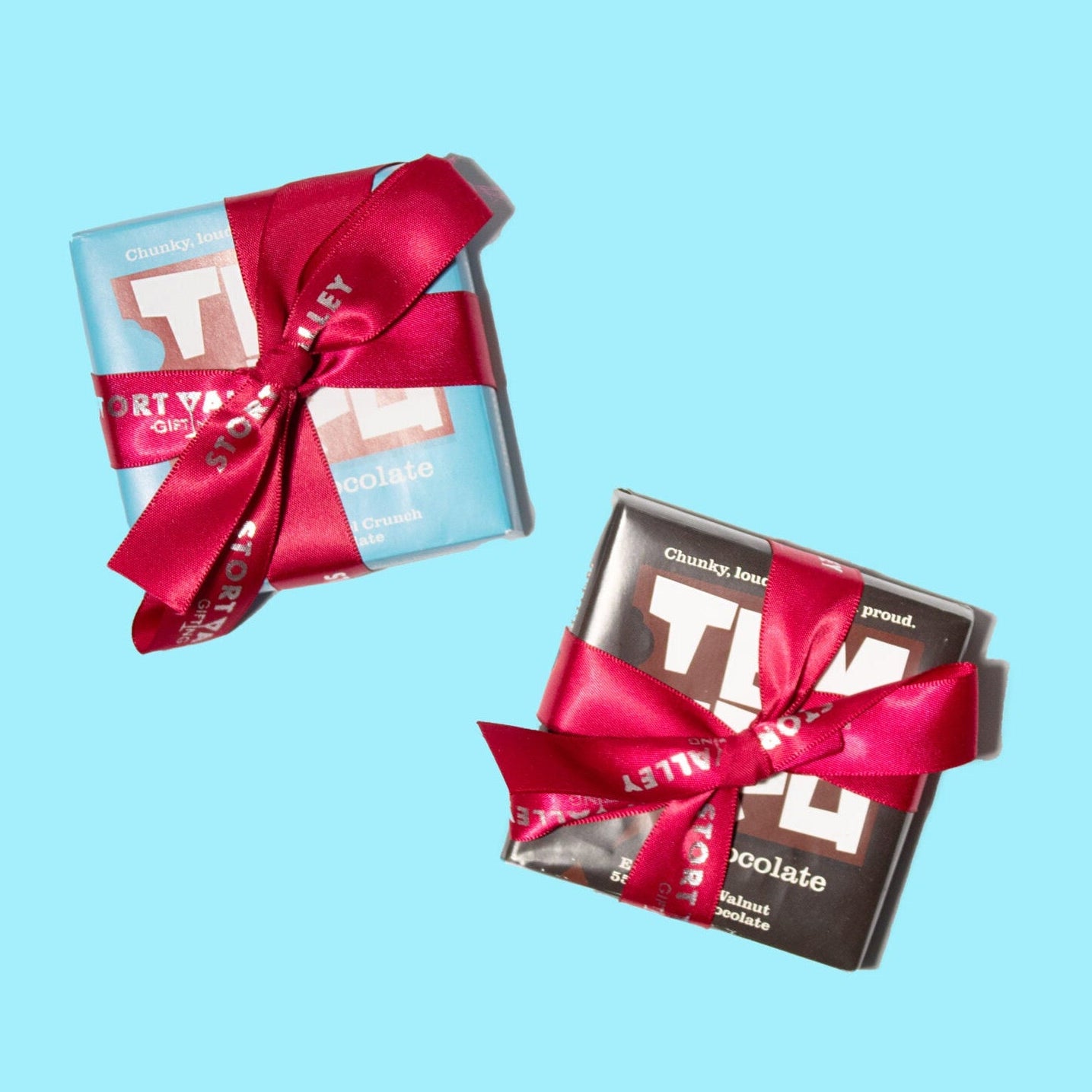 Two Temprd chocolate bars with red ribbons on a light blue background available from Stort Valley Gifting