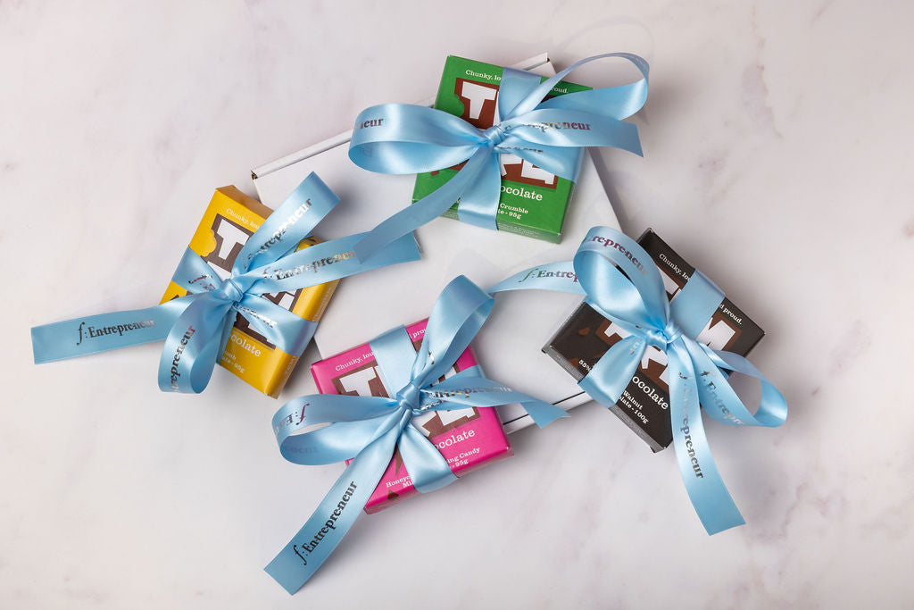 Assorted Temprd chocolate bars with Personalised Stort Valley blue ribbons on a light background